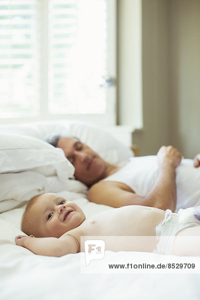 Vater und Baby entspannen sich auf dem Bett