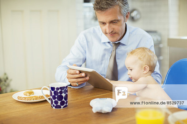 Vater und Baby mit digitalem Tablett