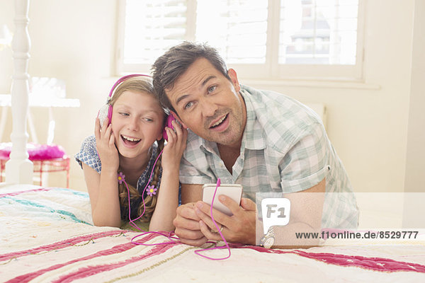 Vater und Tochter hören Kopfhörer