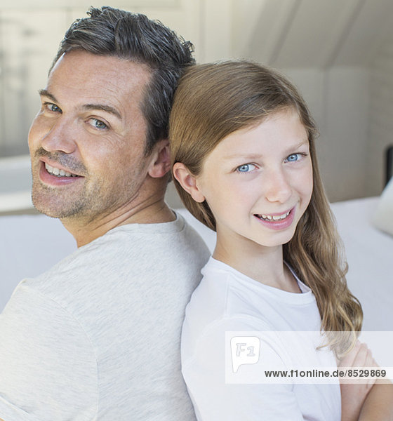Vater und Tochter lächeln im Schlafzimmer