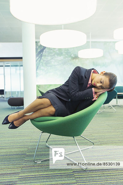 Geschäftsfrau schläft im Bürostuhl