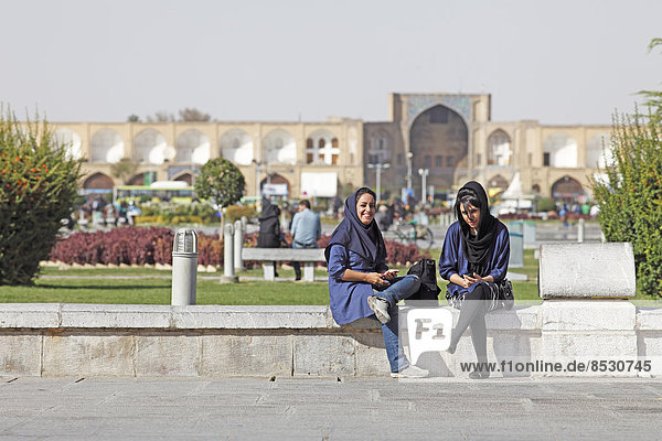 Junge Frauen mit Handy vor dem Eingang zum Basar  Imam-Platz  Isfahan  Provinz Isfahan  Persien  Iran