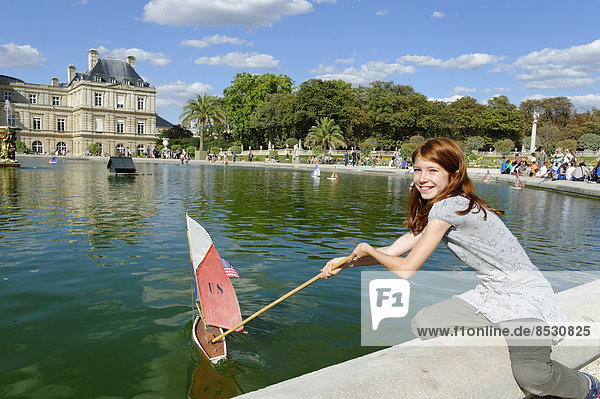 Mädchen spielt mit Schiff am Teich des Palais du Luxembourg  Jardin du Luxembourg  6. Arrondissement  Quartier Latin  Paris  Frankreich