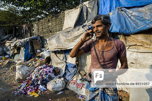 Ein Mann arbeitet im Dharavi Slum  mit einem Telefon  Mumbai  Maharashtra  Indien