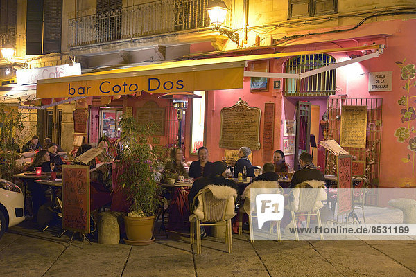 'Guests dining outdoors at the tapas bar ''bar Coto Dos'' in the entertainment district of La Lonja in the evening  Palma  Mallorca  Balearic Islands  Spain'