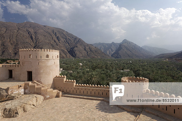 Ausblick vom Fort Nakhl  oder Husn Al Heem  Festung  historischer Lehmbau  über Oase Nakhl auf Jebel Nakhl Massiv  Al-Batinah Provinz  Sultanat von Oman  Arabische Halbinsel