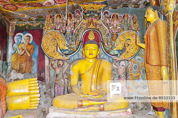 Bunt bemalte und reich verzierte Buddha-Figur  Haltung der Meditation  Dhyana Mudra  Felsentempel Aluvihara  Matale  Zentralprovinz  Sri Lanka