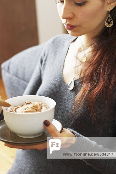 Frau hält Schälchen mit Pastinakencreme