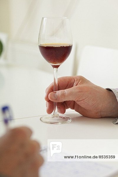 Hand hält Glas mit moussierendem Getränk