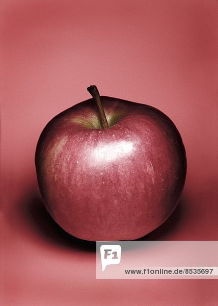 Roter Apfel auf rotem Untergrund