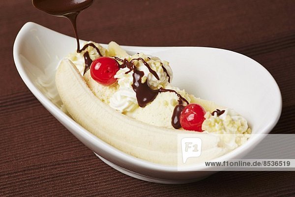 Bananansplit mit Vanilleeis  Banane  Schokoladensauce  Sahne und Kirschen