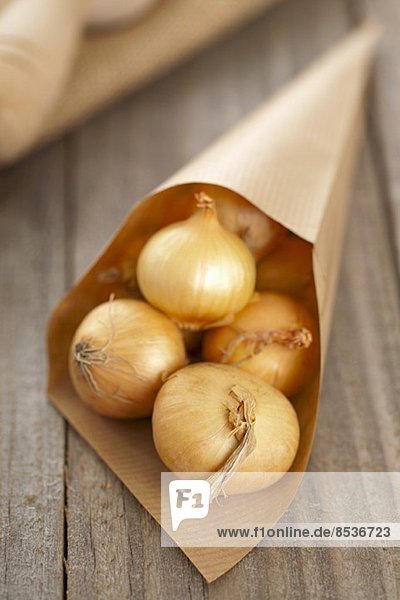 Silverskin onions (whole  with skin) in a paper cone