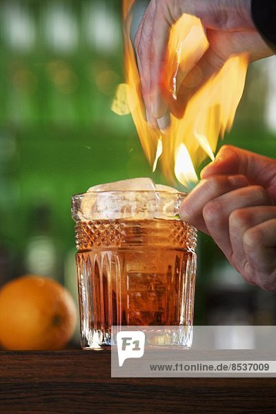 Flambierter Cocktail mit Orange