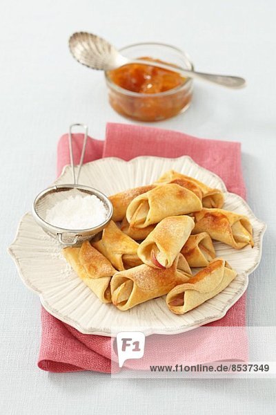 Mini apple turnovers with icing sugar and jam