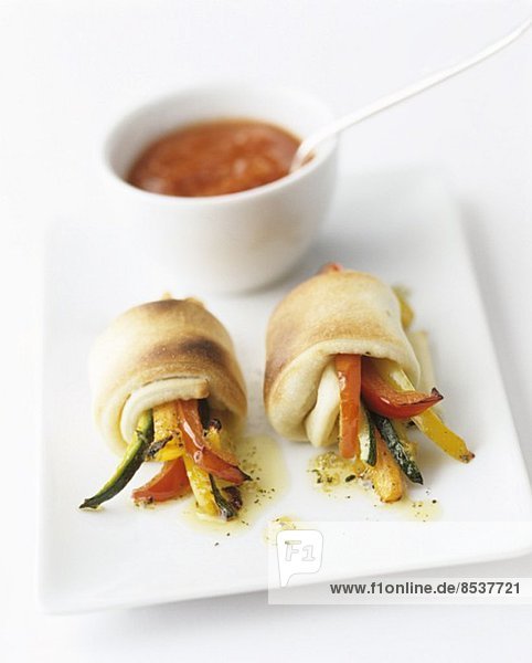 Pan-fried vegetable batons wrapped in dough  with a tomato sauce