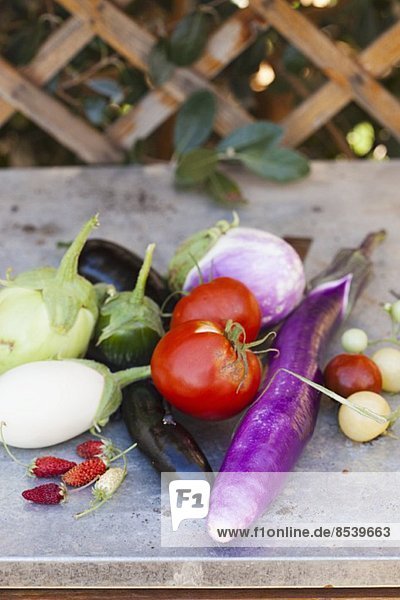 Frisch geerntetes Gemüse und Erdbeeren auf Gartentisch