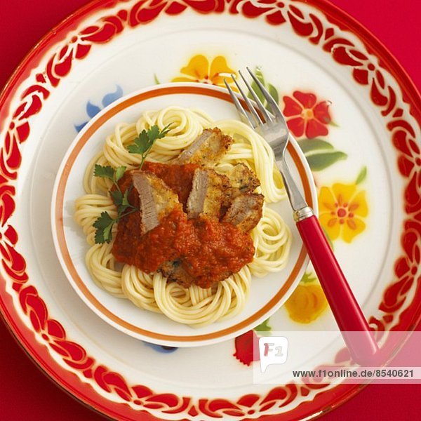Spaghetti with sliced veal schnitzel in tomato sauce
