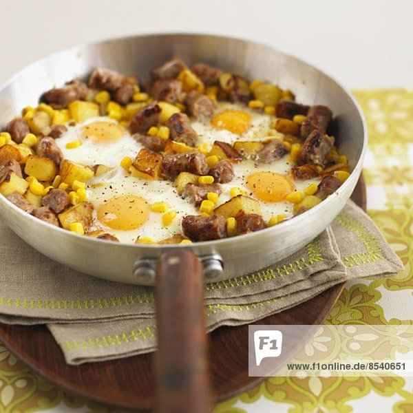 Hash browns with pieces of sausage  sweetcorn and fried eggs