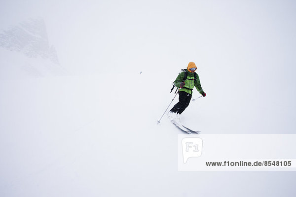 Ein Skifahrer im Pulverschnee bei Nebel- und Wolkenbedingungen auf der Wapta-Traverse  einer Skitour von Hütte zu Hütte in Alberta  Kanada.