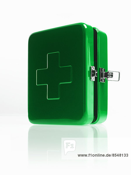 Grüner Erste-Hilfe-Kasten aus Metall mit Verschluss und großem Kreuz auf der Oberseite.