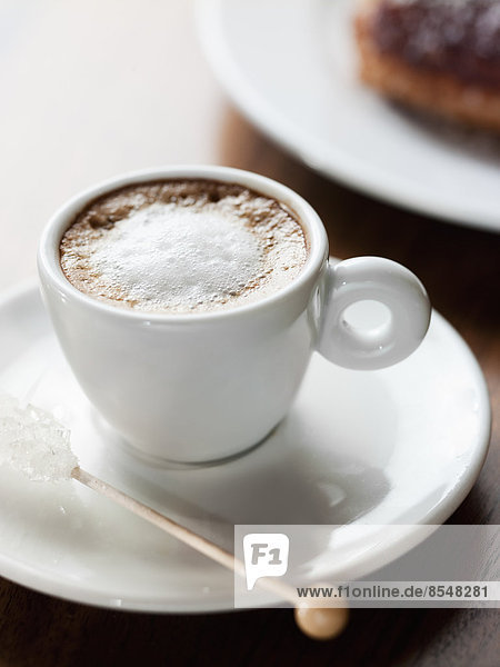 Eine Tasse Kaffee in einer Tasse aus weißem Porzellan. Ein schaumiges Kaffeegetränk.