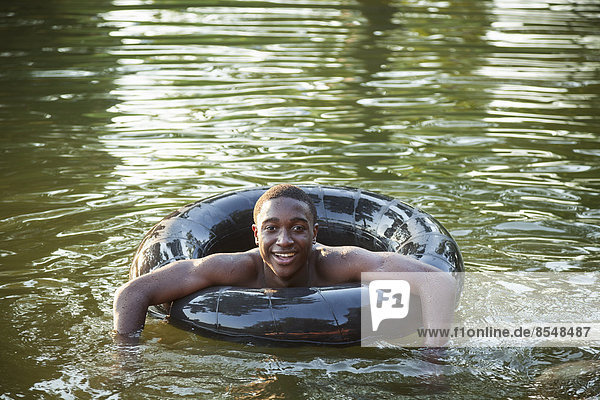 Ein Junge  der mit einem Reifen im Wasser schwimmt  schwimmt im Wasser.