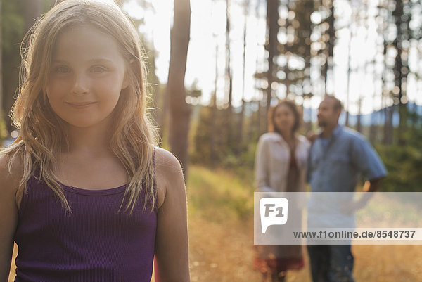 Ein junges Mädchen mit langen blonden Haaren im Wald an der frischen Luft.