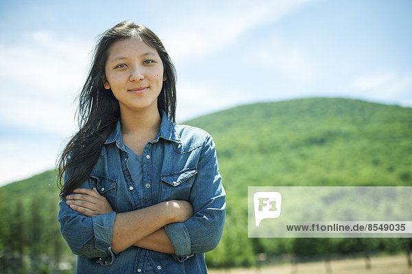 A young woman on a traditional farm in the countryside of New York State  USA