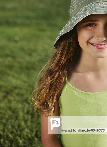 Portrait of smiling nine year old girl  field of grass in background