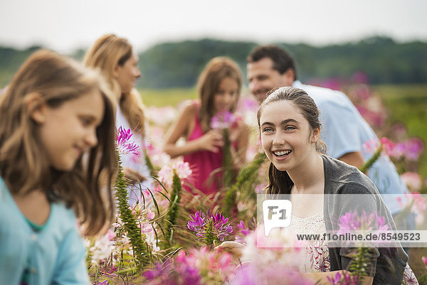 Eine Gruppe von Menschen inmitten der Blumen auf einer Bio-Blumenfarm.