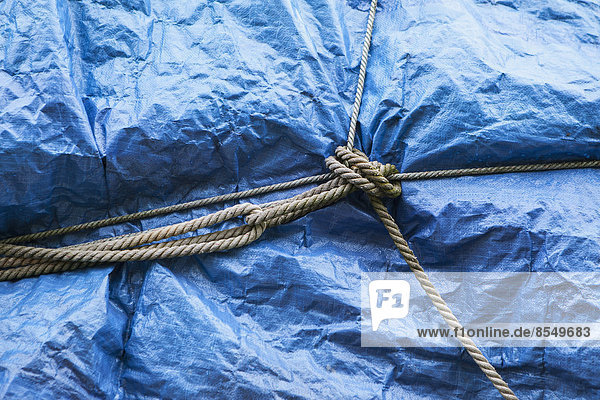 A blue tarpaulin covering stacked commercial fishing nets on the dockside at Fisherman's Wharf  Seattle.