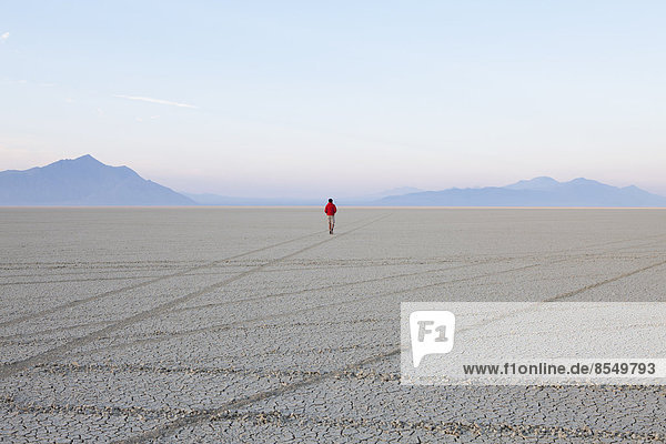 A man in the flat playa  salt pan  of Black Rock Desert  Nevada.