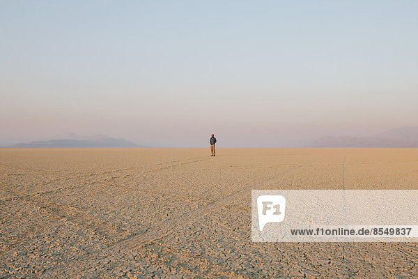Die Figur eines Mannes in der leeren Wüstenlandschaft der Black-Rock-Wüste in Nevada.