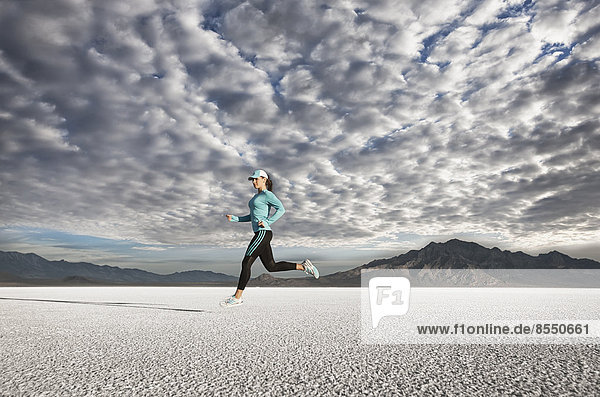 Eine junge Frau läuft durch die Landschaft auf der Salzfläche in der Nähe der Stadt Salt Lake City.