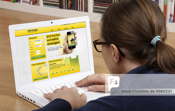 Woman sitting at a laptop surfing the internet  website of ADAC Postbus