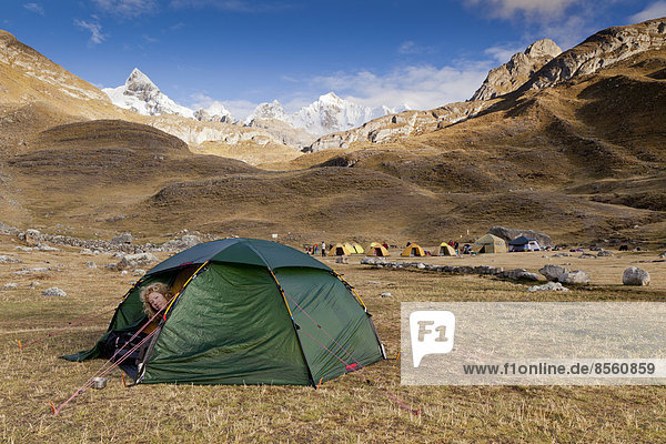Woman looking out of a tent  Cordillera Huayhuash  Peru