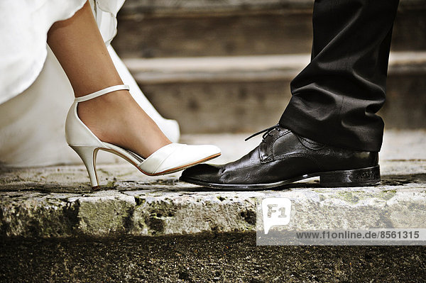 Fuß der Braut tritt auf Fuß des Bräutigams