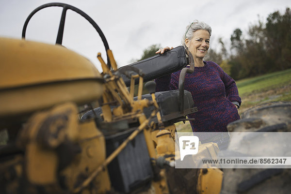 Biolandwirt bei der Arbeit. Eine Frau mit einem Traktor.