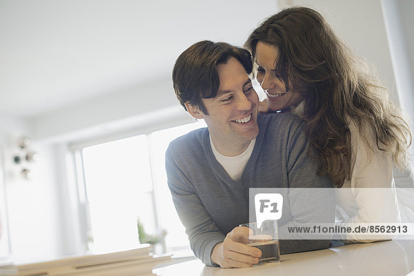 Couple connecting at home in kitchen