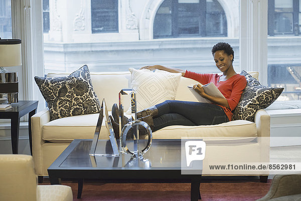 Frau entspannt sich beim Lesen zu Hause