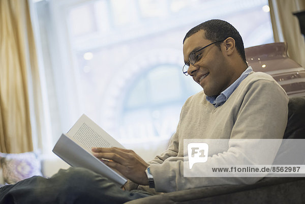 Mann entspannt sich zu Hause beim Lesen