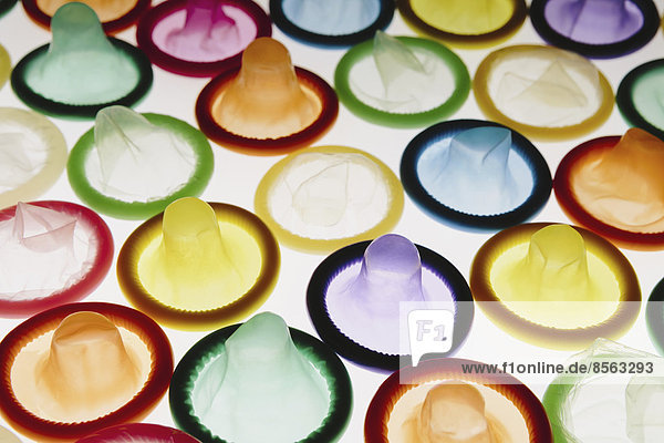 Eine große Gruppe von mehrfarbigen Kondomen auf weißem Hintergrund. Sauber aufgelegt.
