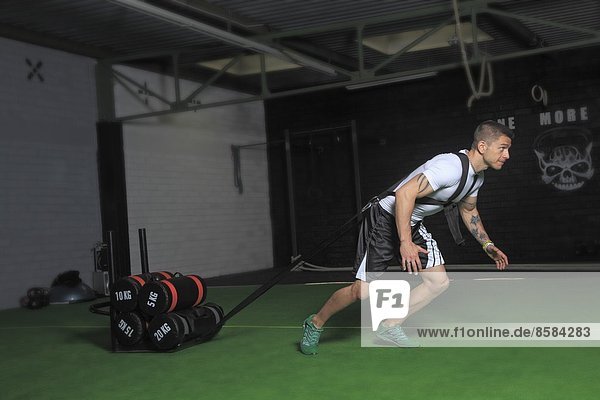 Frankreich Mann der in einer Crossfit-Gymnastikhalle trainiert.