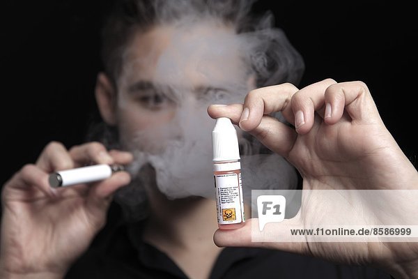 France  young man smoking an electronic cigarette.