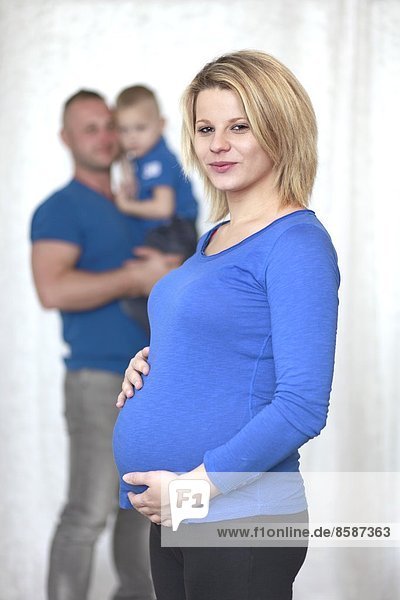 Frankreich  lächelnde Schwangere  ihr Mann und ihr Sohn im Hintergrund.