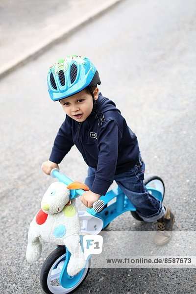 Ein kleiner Junge und sein Fahrrad auf der Straße