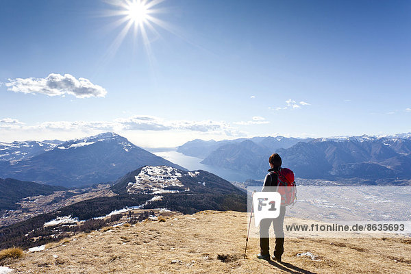 Hiker ascending Monte Stivo mountain  overlooking Lake Garda  Trentino  Italy