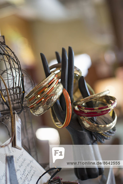 Eine Ausstellung von Ringen und Armreifen und Gegenständen in einem Antiquitätengeschäft.