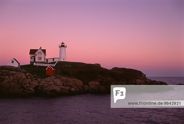 Cape Neddick und der Nubble Lighthouse  auf einer Landzunge an der Küste von Maine bei Sonnenuntergang.