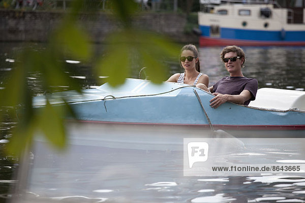 Junges Paar beim Tretbootfahren auf dem See